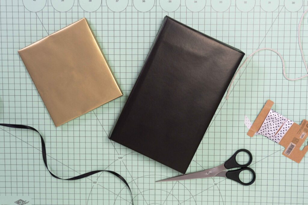 Schlicht verpackte Weihnachtsgeschenke in Gold und Schwarz