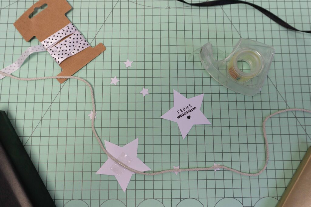 Ausgeschnittene Sternanhänger und Geschenkband