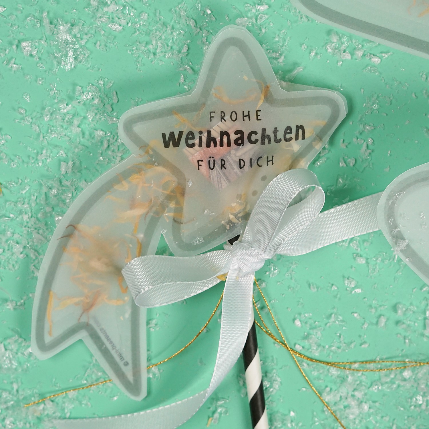 Sternschnuppe am Papierstrohhalm mit Schleife und Spruch Frohe Weihnachten für dich
