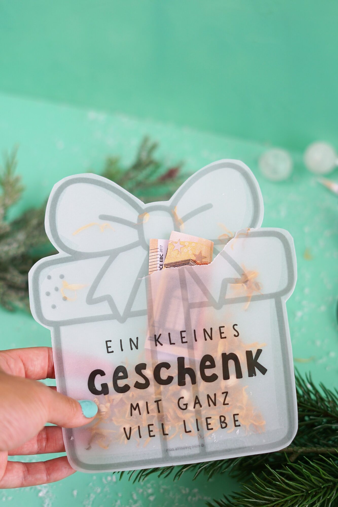 Hand hält die Schüttelkarte Geschenk mit dem Spruch Ein kleines Geschenk mit ganz viel Liebe