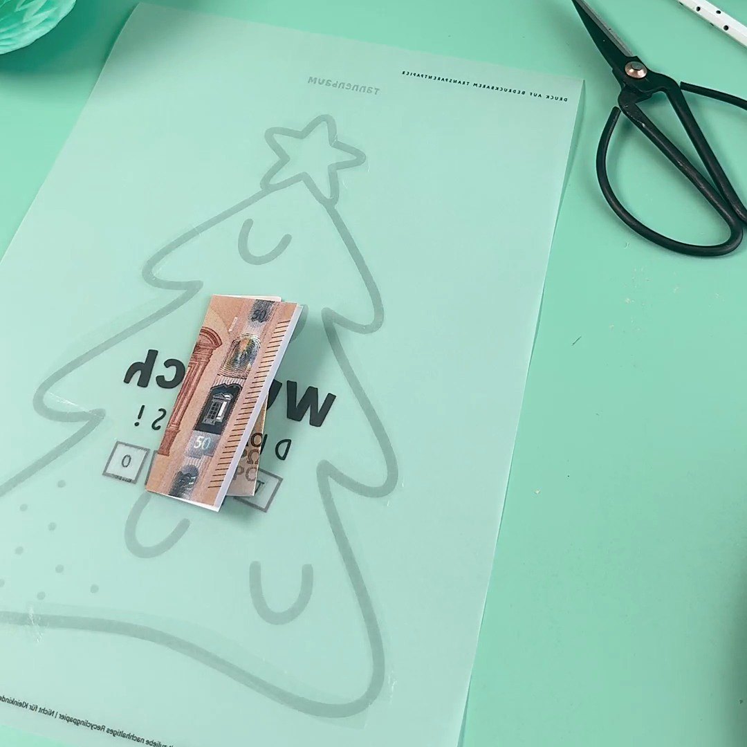 Flach gefalteten Geldschein in die Mitte der Tannenbaum Schüttelkarte legen