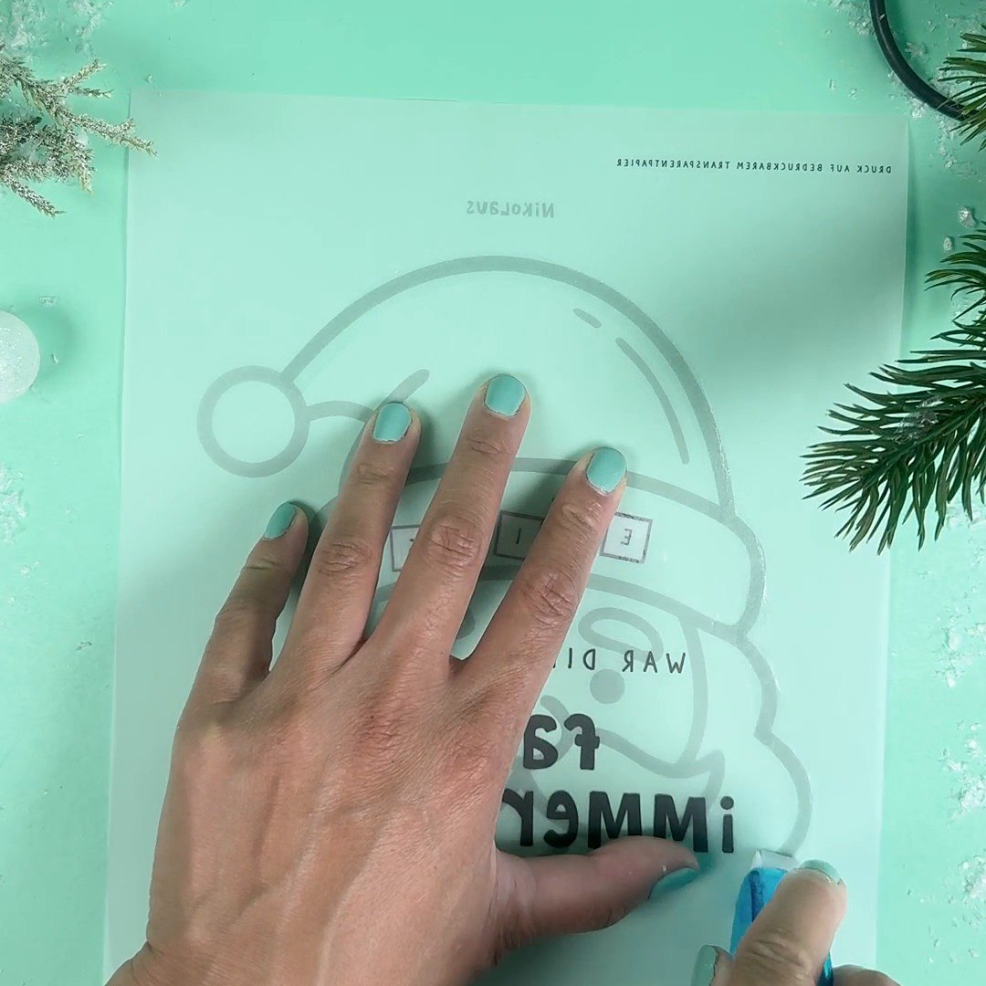 Mit dem Kleberoller an den Kanten der Nikolaus Konfettikarte entlangfahren