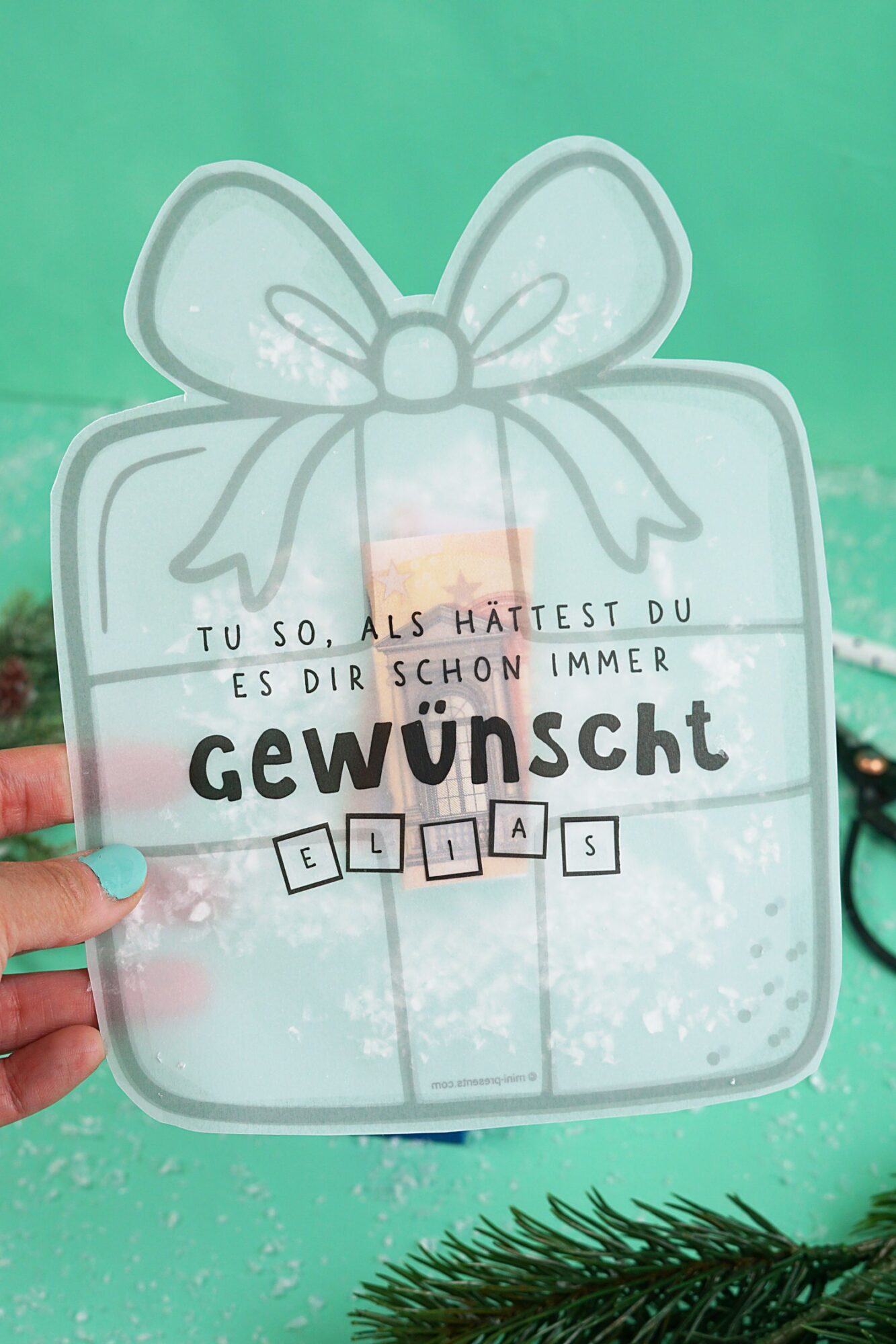Hand hält die Schüttelkarte Geschenk mit dem Spruch Tu so, als hättest du es dir schon immer gewünscht