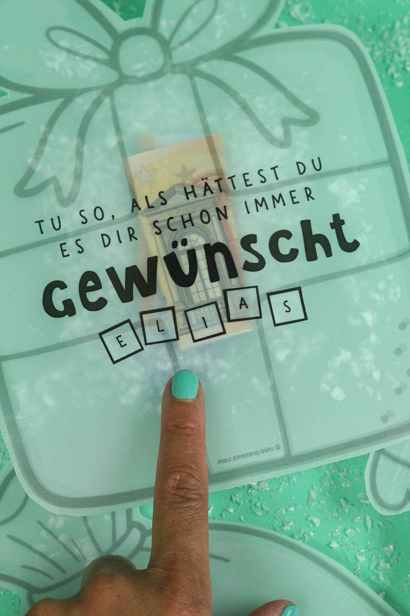 Nahaufnahme der Konfettikarte Geschenk mit Buchstaben für den Namen Elias und Geldschein